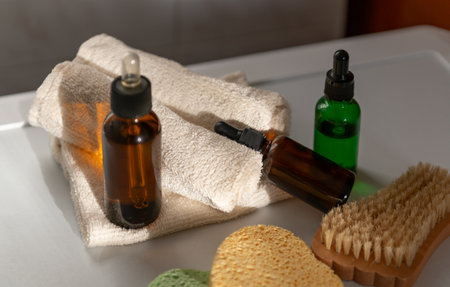Cosmetic dropper bottles with sponges and other tool for beauty routine on sun rays in bathroom, view from above. Beauty care for face and body careの写真素材
