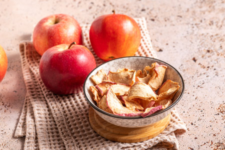 Dried apple slices in a ceramic bowl on the kitchen tableの写真素材