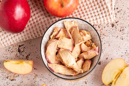 Healthy apple dried snack in ceramic bowl on sunny kitchen top viewの写真素材