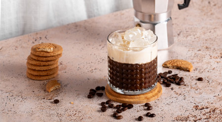 Iced coffee with espresso moka pot and cookies on beige textured countertop, web bannerの写真素材