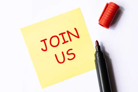 Join us - text on a yellow sticker on white backround with red highlighter. Business concept.の写真素材