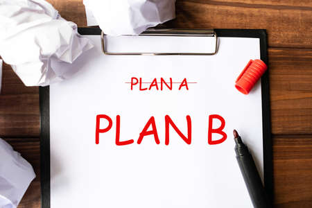 Crossing out Plan A, writing Plan B on a white notebook. Business concept.の写真素材