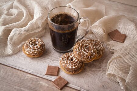 Conceptual coffee morning image, cup of black coffee with beige cookies and chocolate. Symbolic...