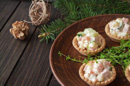 Russian traditional olivier salad in tartlets with potatoes, cucumber, eggs, mushrooms and mayonnaiseの写真素材