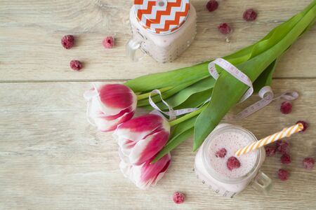 Pink latte healthy beverage trendy beetroot latte and raspberry smoothie, with tulips flowers. Flat lay imageの写真素材