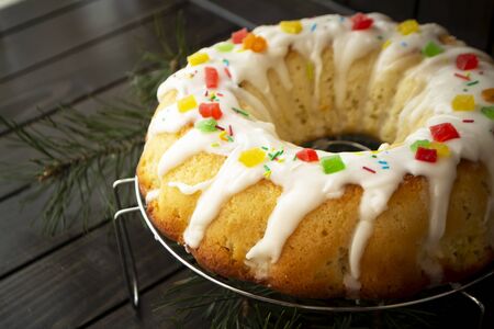 Brioche dough or babka on wooden table with icing and colorful decoration