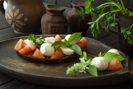 Bruschetta with tomatoes, mozzarella and basil. Traditional italian appetizer or snackの写真素材
