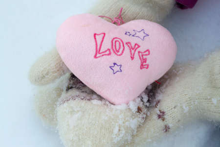 Pink heart in white warm wool glovesの写真素材