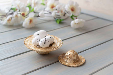 Straw hat decorated for easter with flowers and easter eggs for spring decoration