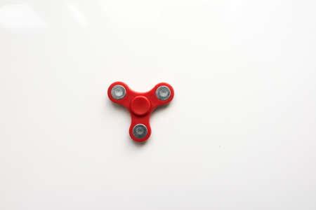 Red  Hand Spiner. Stress relieving toy on white background. Close-up. Top view. Stock photo.の写真素材