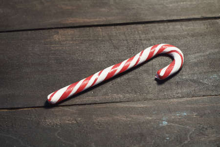 Red and white candy canes on a background of dark wooden planks. Close up. Christmas photoの写真素材
