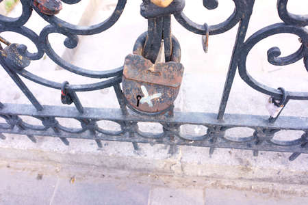 Old padlock on a decorative metal fence. Russian wedding tradition to attach the padlock as a symbol...