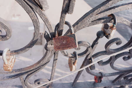 Old padlock on a decorative metal fence. Russian wedding tradition to attach the padlock as a symbol of love and loyalty.の写真素材
