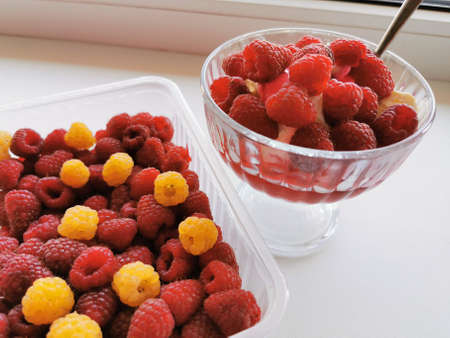 Cream cheese in a glass creamer with fresh red raspberries. Summer dessert. Close-up photo.の写真素材