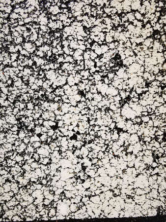 The textured surface of old asphalt, roads, walls with cracked, peeling paint. Grunge background.