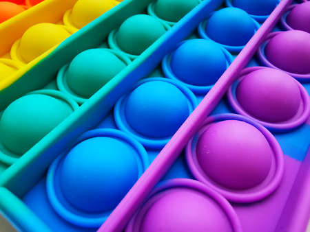 Anti-stress toy poppit. Push bubble toy. Rainbow colors. Close-up. Colored abstract background.の写真素材