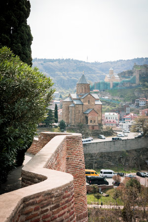 Scenic view of the historic Metekhi Church in Tbilisi, Georgia, with ancient brick wall and...