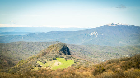 Scenic spring landscape in Kakheti, Georgia, with lush green meadows, forested hills, and distant...