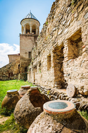 Ancient qvevri vessels and historical walls of Svetitskhoveli Cathedral in Mtskheta, Georgia, under...
