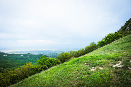 Panoramic view near Kojori, Georgia, with gentle hills and distant plains under a cloudy sky, ideal...