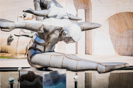 Close-up of a futuristic metal sculpture of a gymnast in a dynamic flying pose at the Cascade Complex in Yerevan, Armenia, with smooth reflections and bright architectural backgroundの写真素材