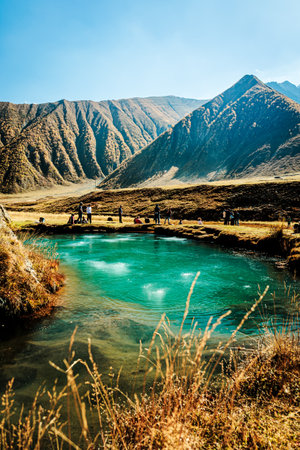 Mineral-rich lake in Truso Valley during autumn. Gaseous springs create an unusual surface pattern in the vivid blue water amid golden hillsの写真素材