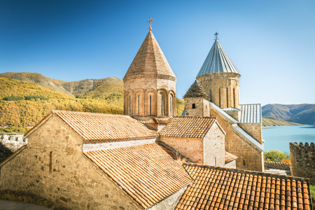 View of the Ananuri fortress complex with ancient churches and towers overlooking Zhinvali Reservoir on a sunny autumn dayの写真素材