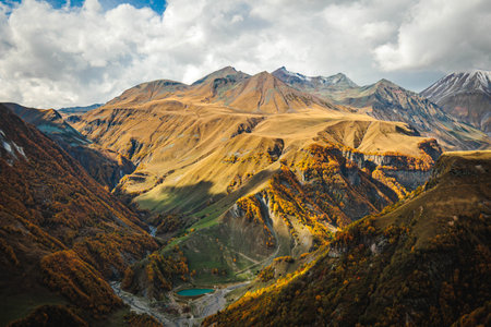 Scenic valley view in the Caucasus mountains of Georgia with a winding river and golden autumn...