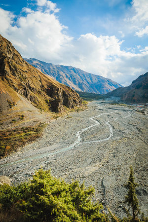 Expansive rocky valley with braided rivers and golden autumn slopes. Peaceful and majestic view of natureの写真素材