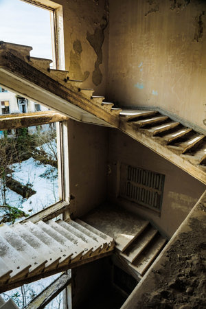 Abandoned sanatorium staircases in Tskaltubo, Georgia. Decaying walls, broken steps, and sunlight create a nostalgic, post-apocalyptic mood of urban explorationの写真素材