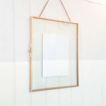 Lifestyle photography featuring blank postcard, note card, invitation, greeting card, art print design. Framed artwork hanging in Scandinavian styled house on white wall background.の写真素材