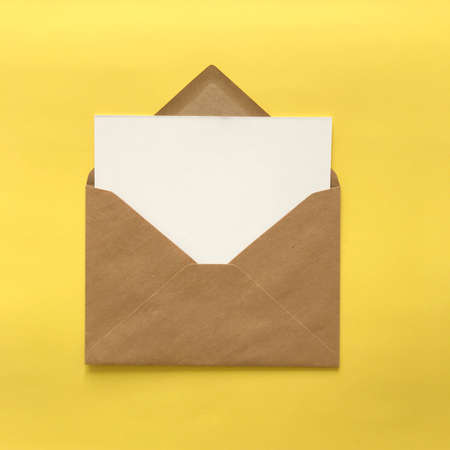 Blank postcard mockup on sunny yellow background with brown paper envelope. Product thumbnail for invitations, leaflets, stationery, cards, flyers. Printed design mock up with white copy space.の写真素材