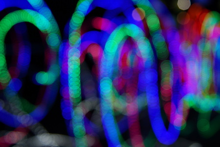 Abstract background of blurred multicolored lines on dark background.