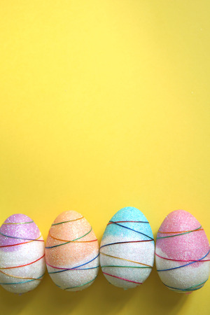 Colorful decorative Easter eggs on yellow background. Copy space.の写真素材