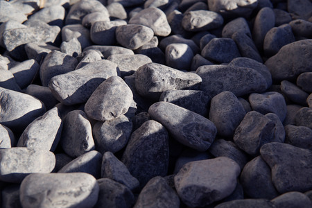 Background of dark grey stones. Partually lighted with the sun.の写真素材