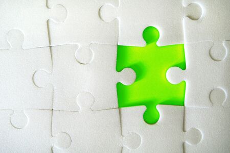 Multiple white puzzle pieces put together without one piece. View from above. Close up image.の写真素材