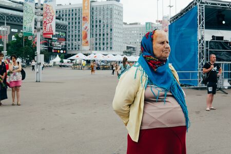 Minsk, Belarus - June 20, 2019. One day before start of 2nd European Games. An old belorussian woman looks at the activities.のeditorial素材