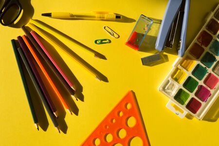 School supplies on a yellow background in bright sun lught. Back to school concept.の写真素材