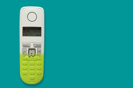 DECT phone turning into a toy phone isolated on blue background. The concept of technology obsolescence. Copy space.の写真素材