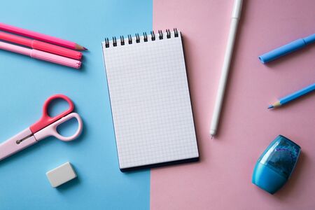 Various stationery and blank notebook on a two-color background. Trendy pink and blue colors. Back to school concept. Mock up, flat lay.の写真素材