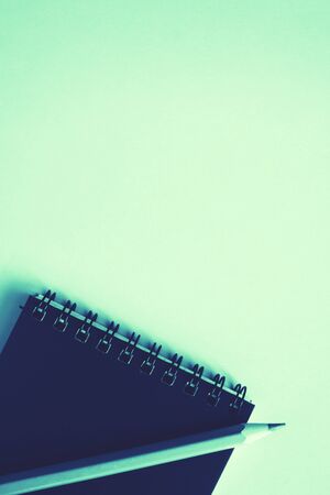 Dark blue notebook, a blue pensil on trendy mint background. Back to school concept. Mock up, flat lay.の写真素材