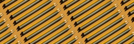 Pattern of trendy gold and silver pencils on gold background. Back to school, education and learning...