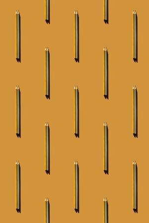 Pattern of trendy gold and silver pencils on gold background. Back to school, education and learning concept. Minimal modern concept, vertical.の写真素材