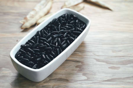 Black beans in a rectangular bowl on a wooden backgroundの写真素材