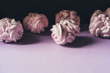Fresh marshmallows on a purple background. Zephyr, meringue. The concept of home-cooked food, sweets. Minimalism, top view, flat lay, copyspace.の写真素材