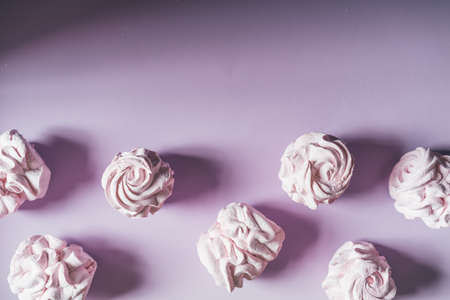 Fresh marshmallows on a purple background. Zephyr, meringue. The concept of home-cooked food, sweets. Minimalism, top view, flat lay, copyspace.の写真素材