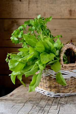 Sorrel leaves in a basket on a wooden tableの写真素材