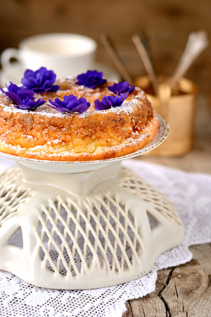 Casserole of cottage cheese with violets on wooden tableの写真素材