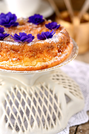 Casserole of cottage cheese with violets on wooden tableの写真素材