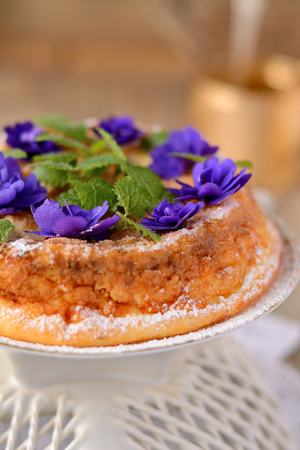 Casserole of cottage cheese with violets on wooden tableの写真素材